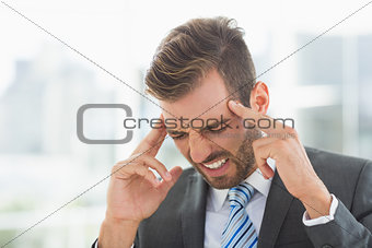 Closeup of a young businessman with headache
