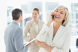 Businesswoman on call with colleagues discussing at office