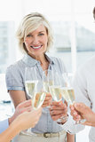 Businesswoman toasting with champagne in office