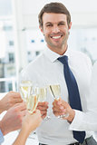 Businessman toasting with champagne in office