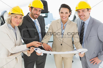 Well dressed architects with hard hats and blueprint