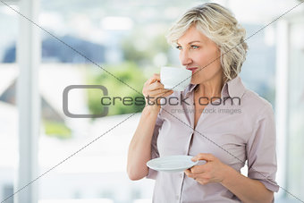 Smiling beautiful businesswoman drinking tea