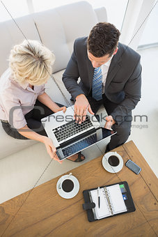 Businessman and his secretary with laptop and diary at home