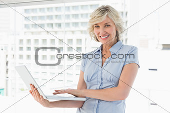 Portrait of a happy businesswoman using laptop