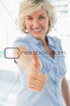 Elegant businesswoman gesturing thumbs up