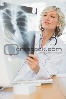 Serious female doctor examining xray