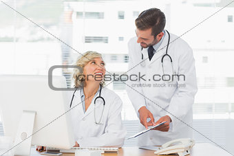 Doctors using digital tablet at medical office