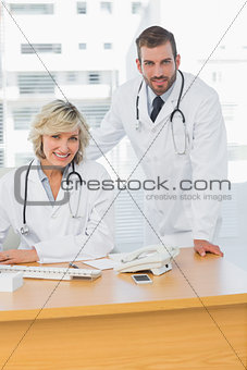 Smiling doctors with computer at medical office