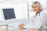 Female doctor using computer at desk in medical office