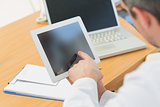 Doctors using laptop and digital tablet in meeting