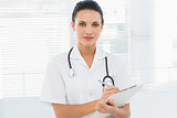 Beautiful young female doctor with clipboard