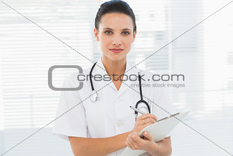 Beautiful young female doctor with clipboard