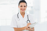Portrait of a beautiful young female doctor with clipboard