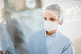 Serious female surgeon examining blurred xray