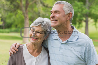 Smiling senior couple with arms around at park