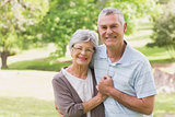 Loving happy senior couple holding hands at park