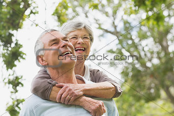 Senior woman embracing man from behind