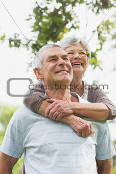 Senior woman embracing man from behind