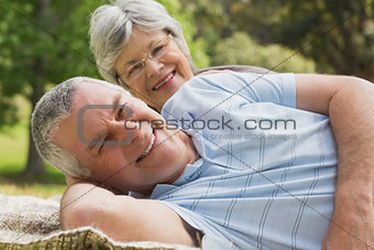 Closeup portrait of a senior couple lying at park