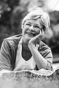 Smiling senior woman lying at park