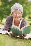 Senior woman reading a book at park