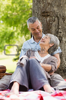 Happy relaxed senior couple sitting at park
