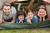Couple with kids lying in the tent at park