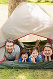 Couple with kids lying in the tent at park