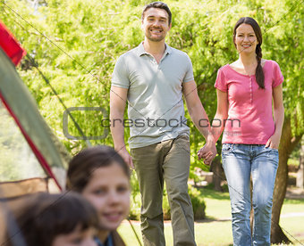 Kids in tent with couple in background at park