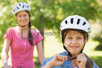 Smiling woman with her daughter riding bicycle