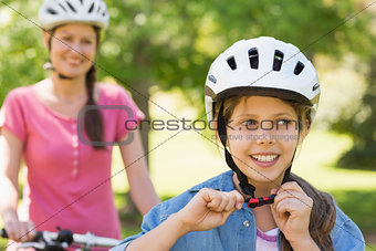 Smiling woman with her daughter riding a bicycle