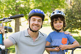 Smiling man with his son riding bicycles