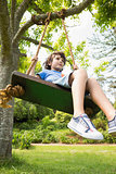Low angle view of a cute little boy on swing