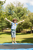 Happy boy jumping high on trampoline  in the park