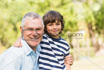 Grandfather and son smiling in park