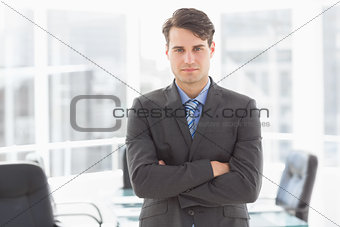 Handsome businessman leaning on board room table