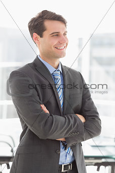 Handsome smiling businessman with arms crossed