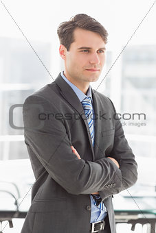 Handsome focused businessman with arms crossed