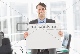 Handsome happy businessman holding placard