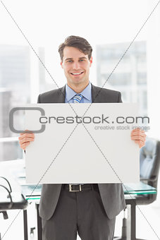 Handsome smiling businessman holding placard