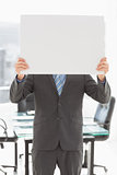 Businessman holding poster over his face