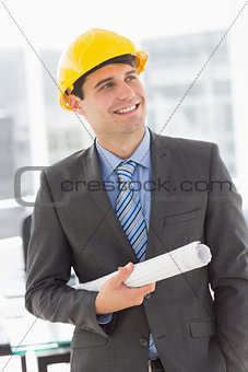 Happy architect smiling and holding blueprints
