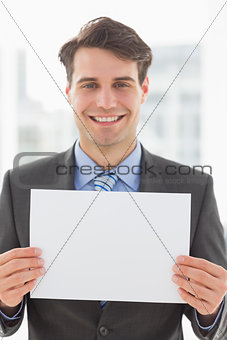 Happy businessman holding blank page
