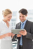 Smiling business team looking at tablet pc together