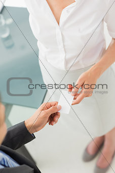 Businessman giving businesswoman his card