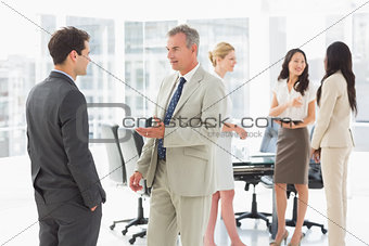 Business people speaking together in conference room