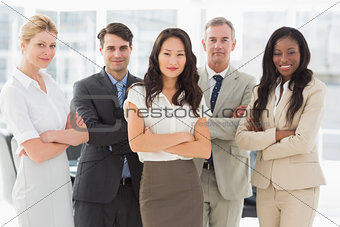 Business team smiling at camera with arms crossed