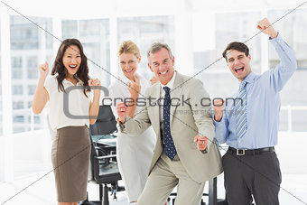 Business team cheering at the camera