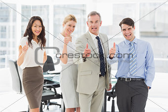 Business team giving thumbs up to the camera