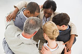 Close business team embracing in a circle